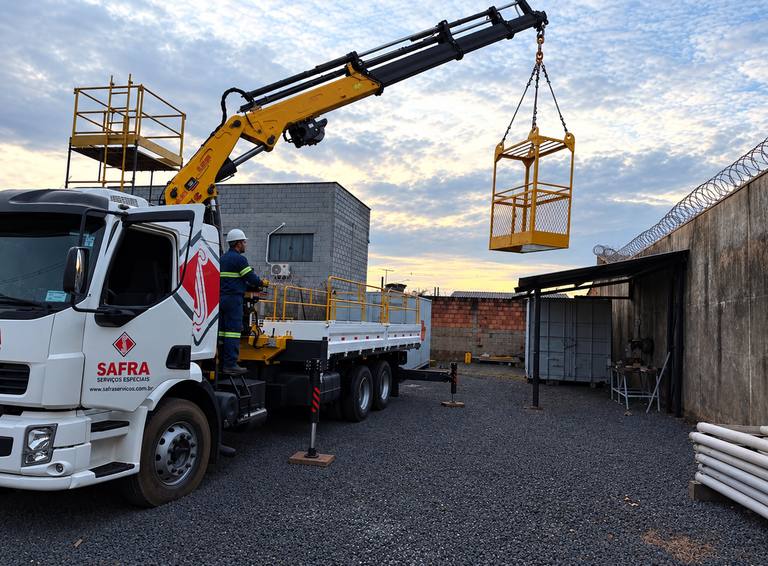 Caminhão munck da Zeta Locações içando cesto aéreo em indústria, em Uberlândia e região